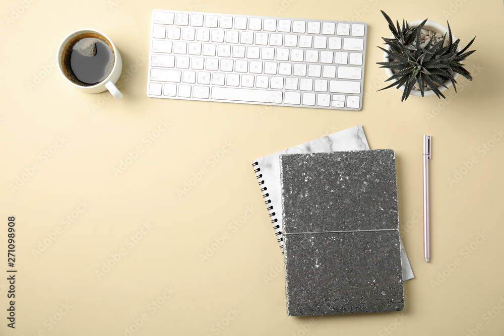 Blogger's workplace with notebooks and keyboard on color background, flat lay. Space for text