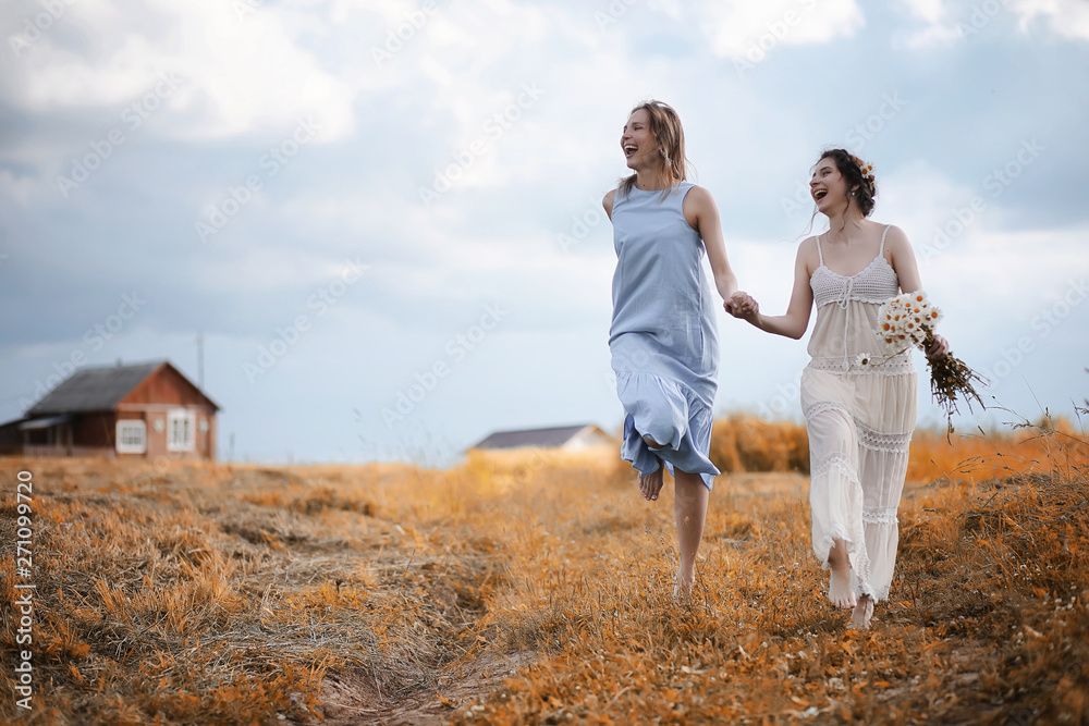 Two girls in dresses in autumn field