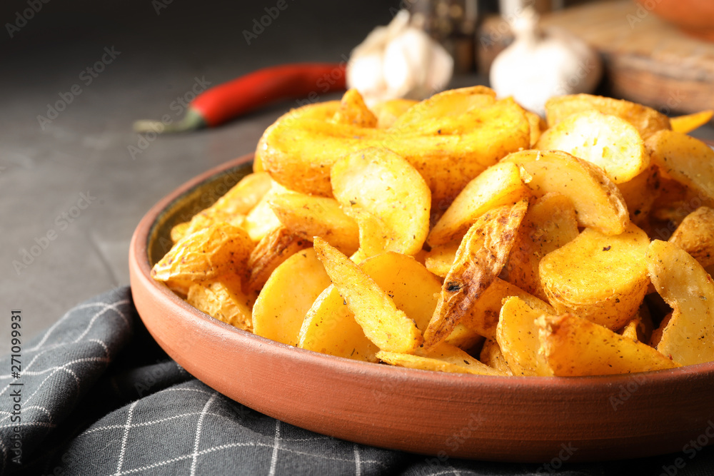 Plate of delicious oven baked potatoes on table, closeup Plate of delicious oven baked potatoes on table, closeup
