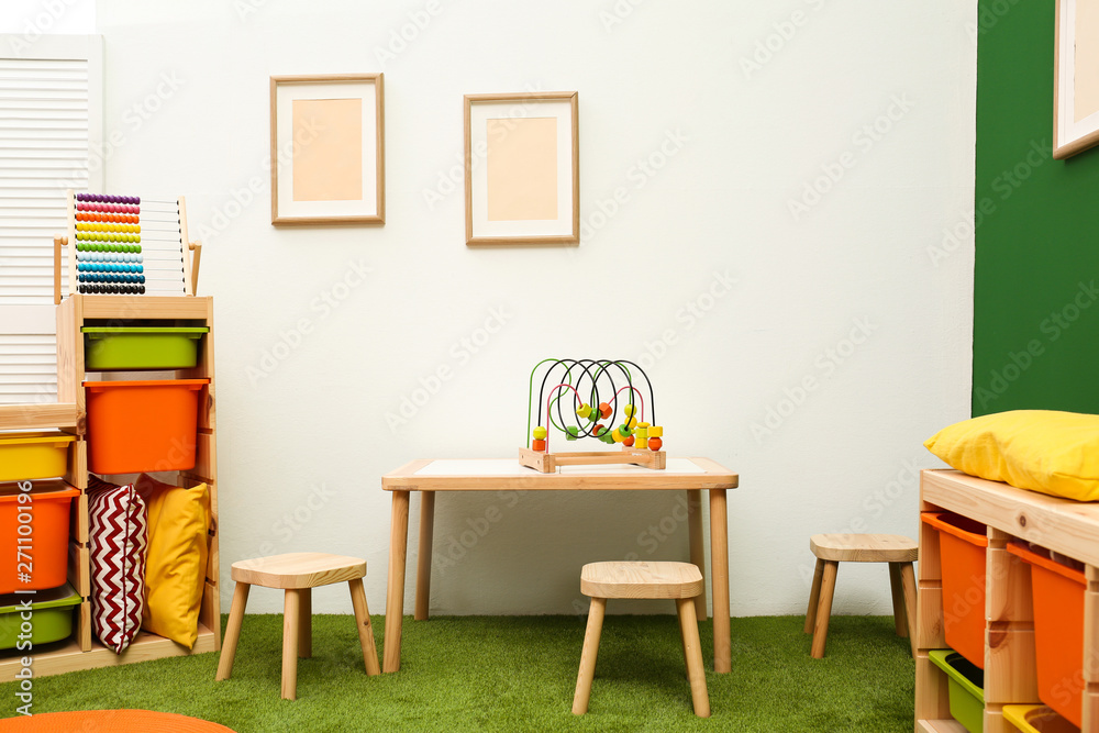 Stylish playroom interior with table and stools Stylish playroom interior with table and stools