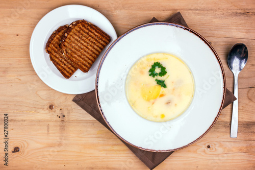 Cheese soup in a white plate with toasted bread