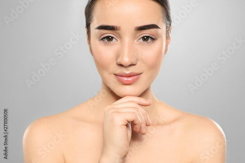 Portrait of young woman with beautiful face against color background