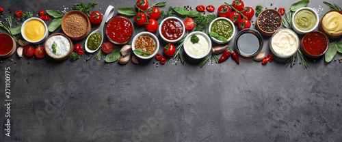 Flat lay composition with different sauces and space for text on gray background