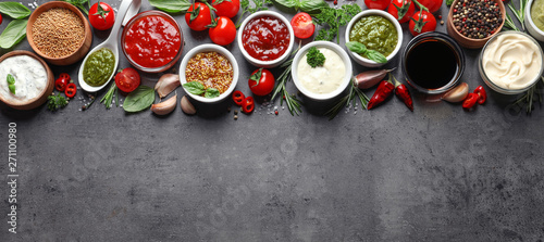 Flat lay composition with different sauces and space for text on gray background