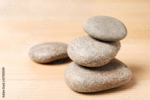 Stack of spa stones on wooden table. Space for text