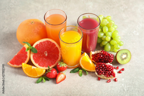 Fototapeta Naklejka Na Ścianę i Meble -  Glasses of different juices and fresh fruits on table