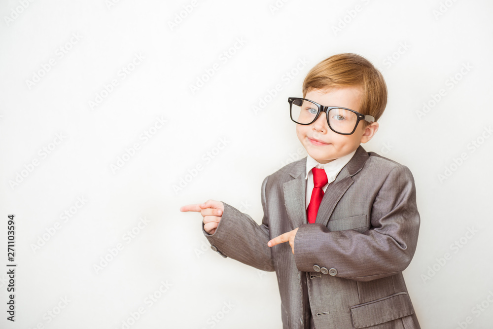 Smiling child boy pointing his index finger at something on white background. Success, creative and innovation business concept Smiling child boy pointing his index finger at something on white background. Success, creative and innovation business concept
