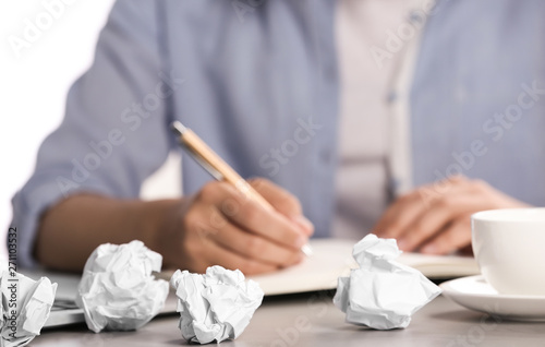Woman working at table with crumpled paper, closeup. Generating idea