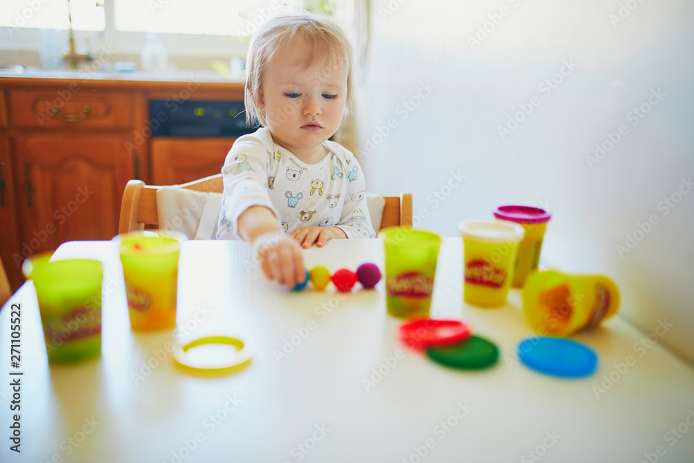 Adorable little girl playing with modelling clay Adorable little girl playing with modelling clay