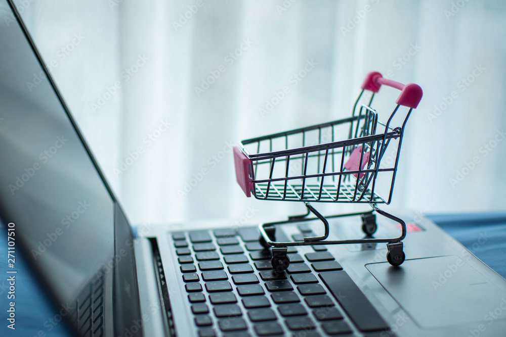 shopping cart on computer, shopping online concept. subject is blurred and low key.