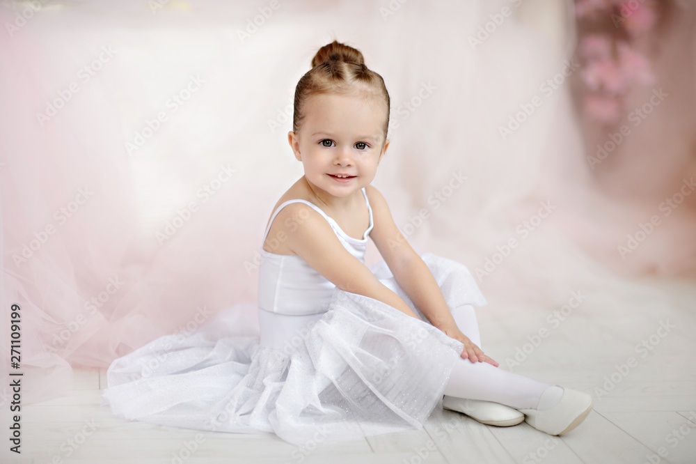 Beautiful small girl in white dress posing indoor. Beautiful small girl in white dress posing indoor.