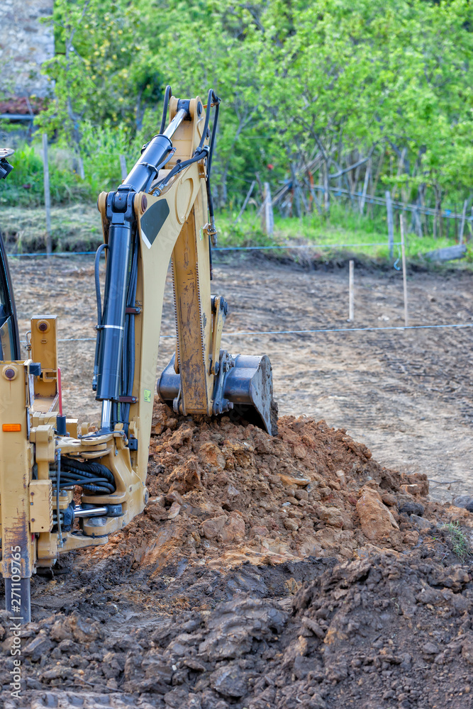 Fototapeta premium A backhoe excavating earth in a construction site