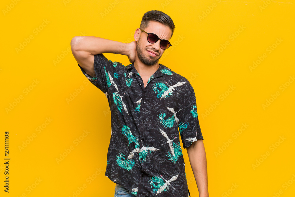 Young filipino man wearing summer clothes suffering neck pain due to sedentary lifestyle.