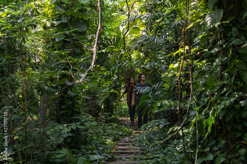 male travelers walking through jungle. they are hiking in forest dense. concept of Travel, trip, Holiday and vacation.