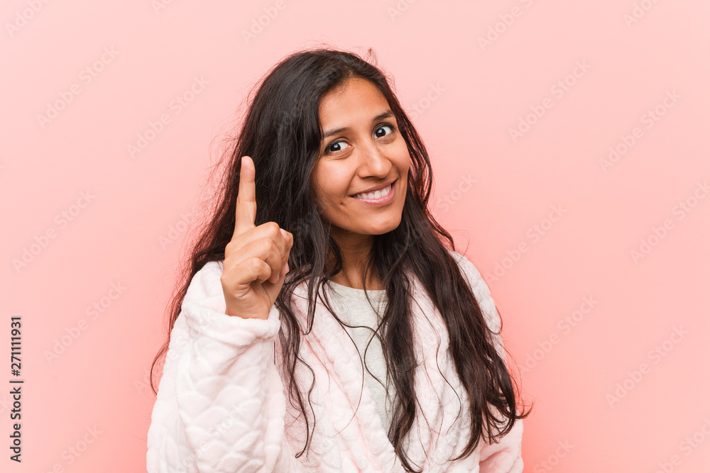Young indian woman wearing pajama having an idea, inspiration concept.