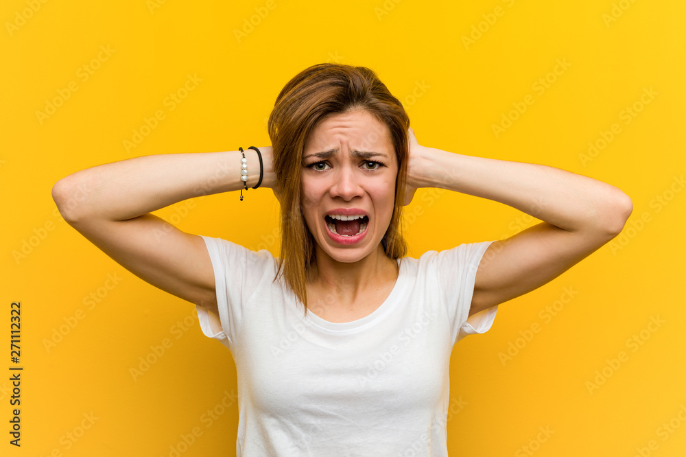 Young natural caucasian woman covering her ears with hands trying not to hear too loud sound. Young natural caucasian woman covering her ears with hands trying not to hear too loud sound.