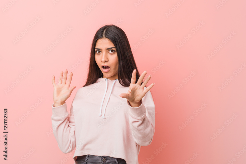 Young pretty arab woman wearing a casual sport look being shocked due to an imminent danger Young pretty arab woman wearing a casual sport look being shocked due to an imminent danger