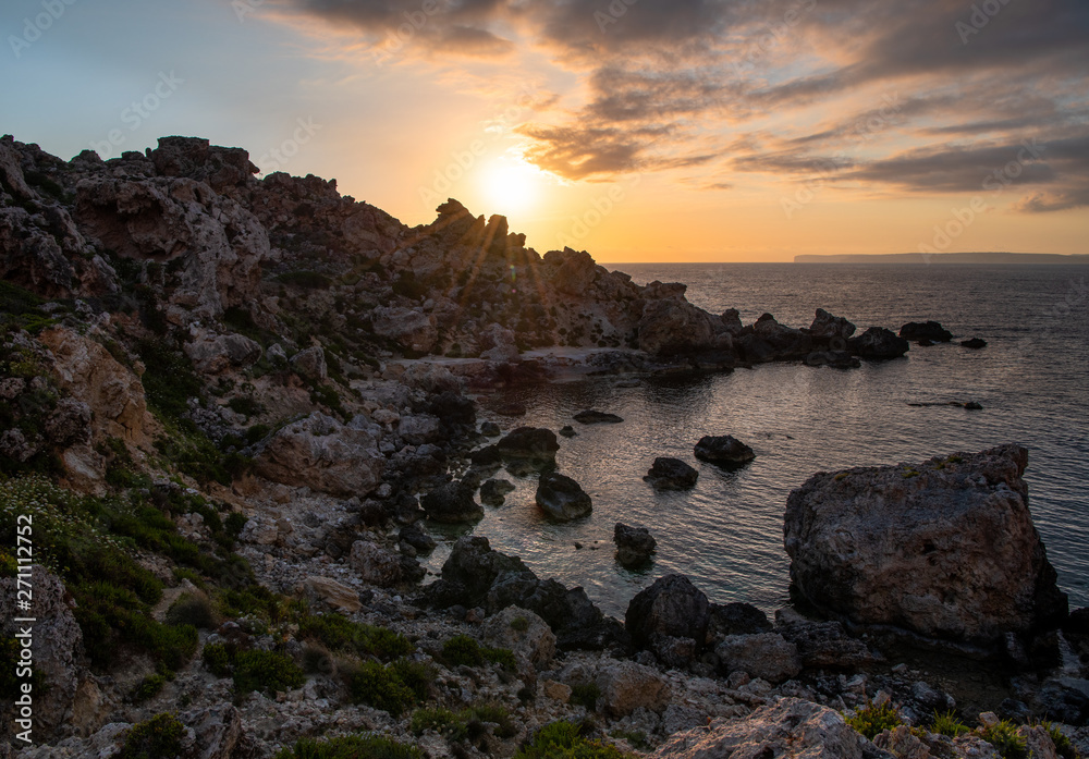 Fototapeta premium A beach full of fallen boulder during sunset