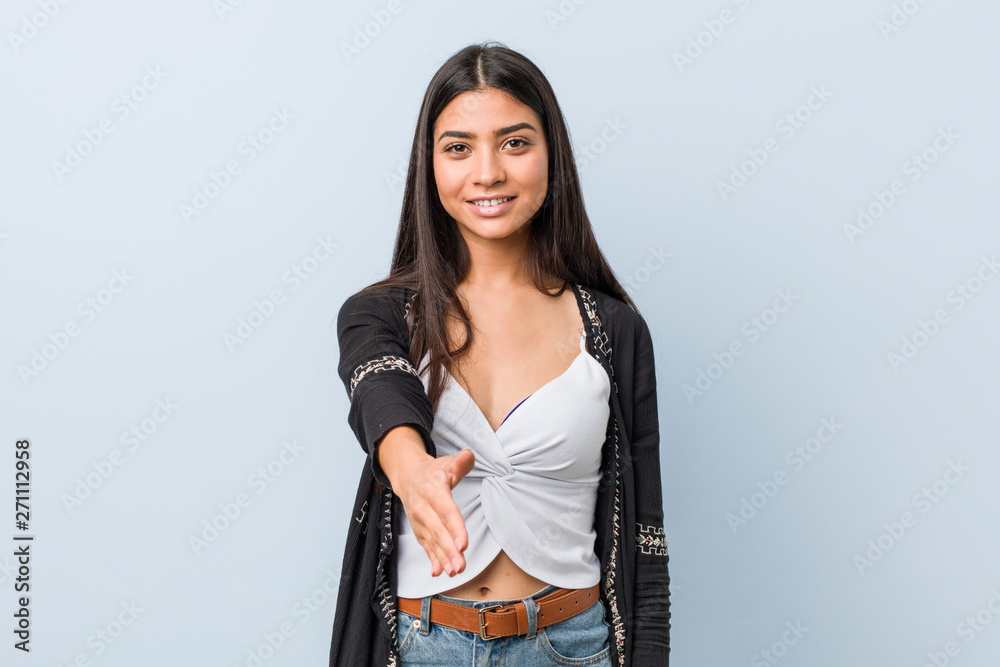 Young natural and pretty arab woman stretching hand at camera in greeting gesture. Young natural and pretty arab woman stretching hand at camera in greeting gesture.