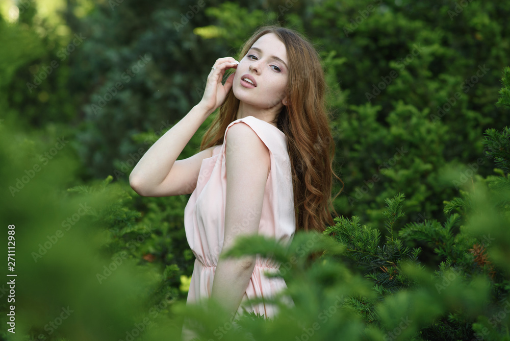 Beautiful and happy young girl walks in the park and enjoys life Beautiful and happy young girl walks in the park and enjoys life