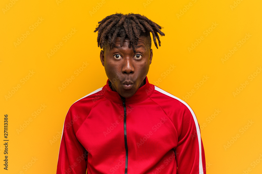 Young fitness black man shrugs shoulders and open eyes confused. Young fitness black man shrugs shoulders and open eyes confused.