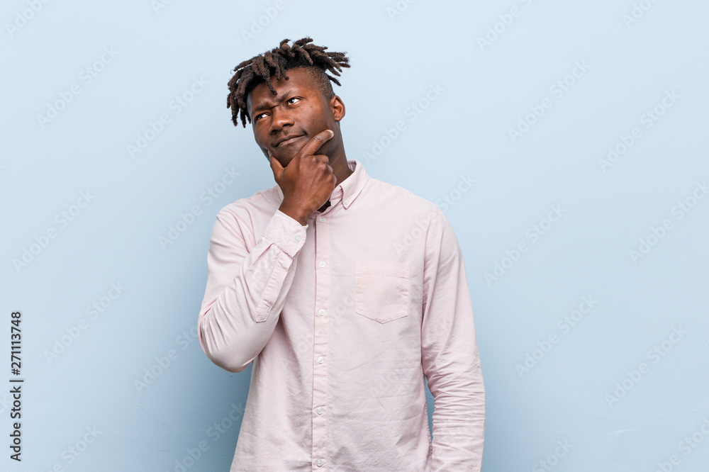 Young business african black man looking sideways with doubtful and skeptical expression.