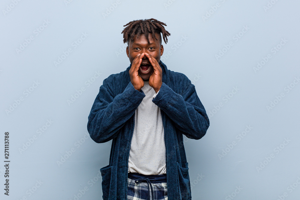 Young african black man wearing pajama shouting excited to front. Young african black man wearing pajama shouting excited to front.