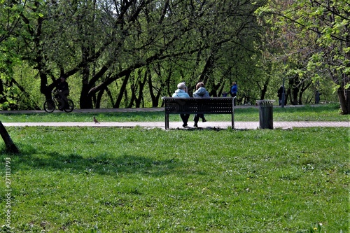 People in the city park. Women relax on the bench.