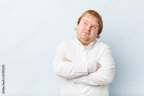 Young authentic redhead fat man unhappy looking in camera with sarcastic expression.