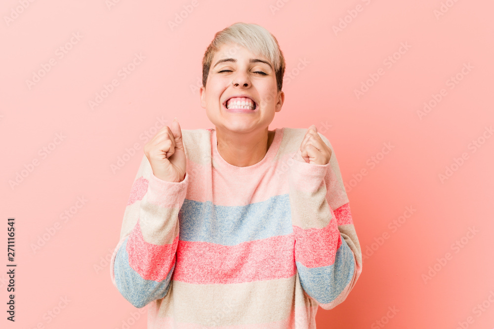 Young natural curvy woman raising fist, feeling happy and successful. Victory concept. Young natural curvy woman raising fist, feeling happy and successful. Victory concept.