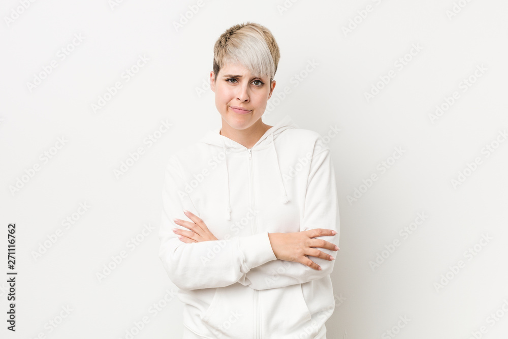 Young curvy woman wearing a white hoodie unhappy looking in camera with sarcastic expression. Young curvy woman wearing a white hoodie unhappy looking in camera with sarcastic expression.