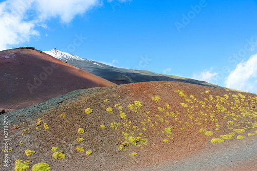 Beautiful view of the top of Mount Etna in Sicily, Italy surrounded by volcanic landscape. Snow on the very top of the mountain. Taken on a sunny day with blue sky photo