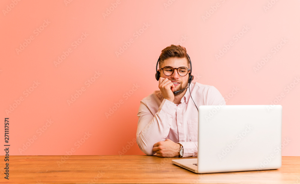 Young man working in a call center relaxed thinking about something looking at a copy space. Young man working in a call center relaxed thinking about something looking at a copy space.