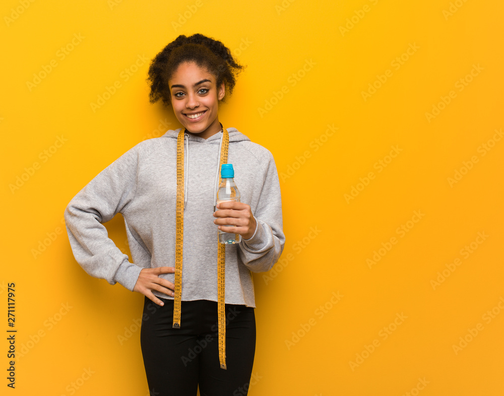 Young fitness black woman with hands on hips.Holding a water bottle. Young fitness black woman with hands on hips.Holding a water bottle.