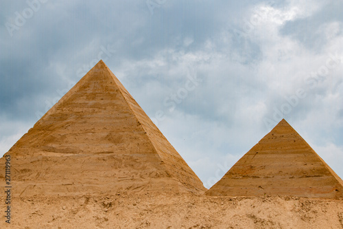 two pyramids of sand on the background of thunderclouds