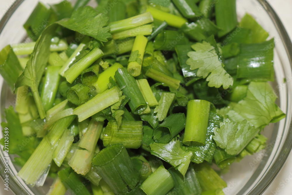 Glass bowl of cilantro and chives sliced. Ingredients to make a healthy dish Glass bowl of cilantro and chives sliced. Ingredients to make a healthy dish