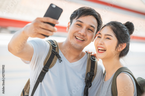 Canvas Print Asian blogger couple travel in Bangkok, Thailand, sweet couple using mobile phone selfie photo view while spending sweet time in holiday trip