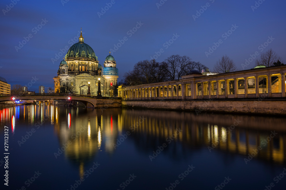 Beautiful view of the illuminated Berliner Dom (Berlin Cathedral) and colonnade on the Museum Island and reflections on the Spree River in Berlin, Germany, at dusk.