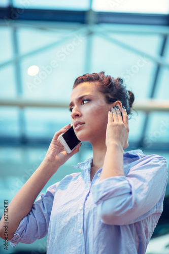 gorgeous woman talking on mobile phone at airport