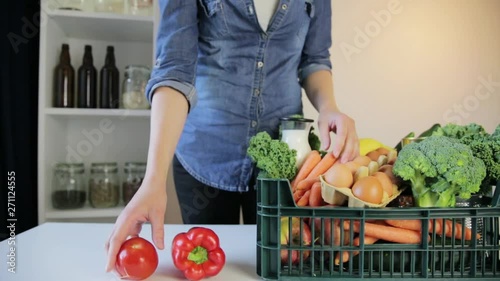 Food delivery service - woman with groceries box on gray background