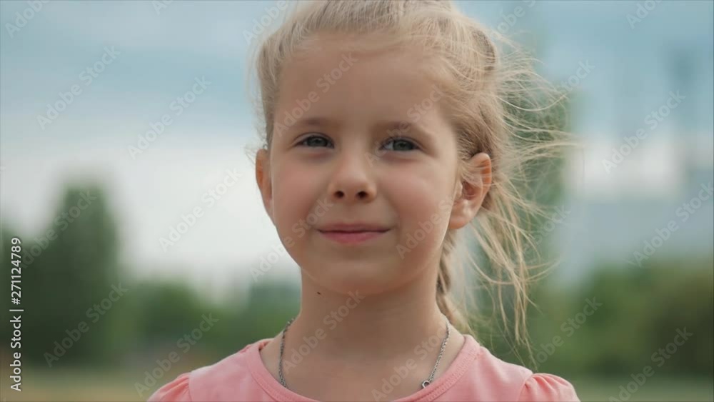 Close Up Portrait Cute Happy Caucasian Little Girl Smiling Looking the Camera, Enjoying Warm Summer Vacation Sunny day. Close Up Portrait Cute Happy Caucasian Little Girl Smiling Looking the Camera, Enjoying Warm Summer Vacation Sunny day.