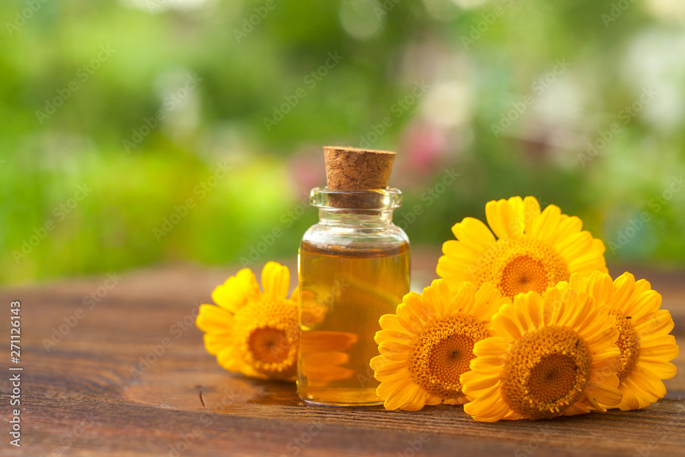 Essence of Agrimonia flowers on table in beautiful glass Bottle Essence of Agrimonia flowers on table in beautiful glass Bottle