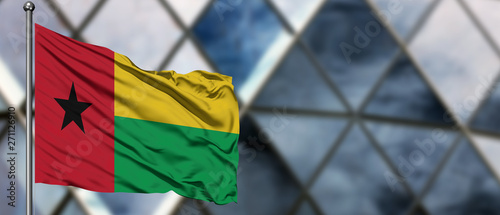 Canvas Print Guinea Bissau flag waving in the wind against blurred modern building