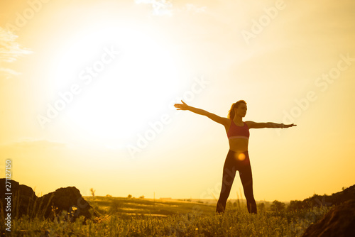 Woman Doing Stretching Outdoor. Warm up Exercise Against Sunset. Sport and Healthy Active Lifesyle Concept.