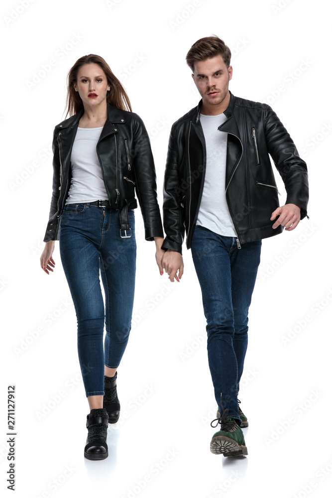 Fototapeta premium Determined couple stepping forward and holding hands