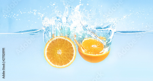 Fototapeta Naklejka Na Ścianę i Meble -  Splash of falling in water fresh orange halves