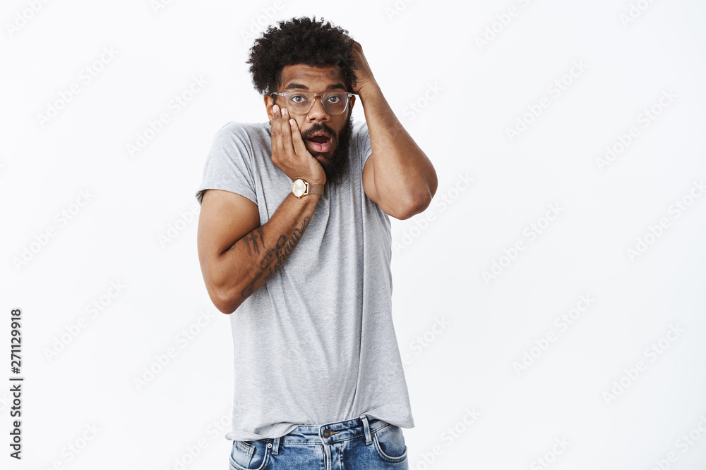 Stunned speechless and shocked guy reacting to rough fight happening near him grabbing head open mouth and standing in stupor astonished and puzzled posing shook over gray background Stunned speechless and shocked guy reacting to rough fight happening near him grabbing head open mouth and standing in stupor astonished and puzzled posing shook over gray background