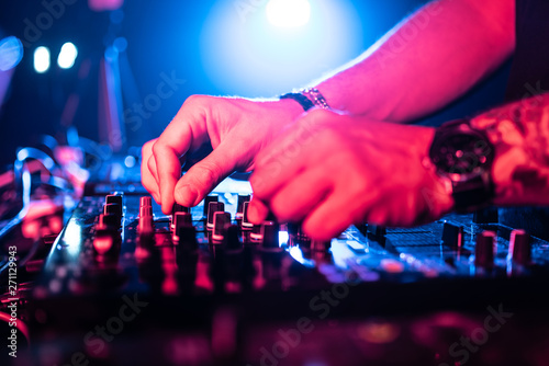 Close up of DJ Hands Controlling Music Table in a Night Club.