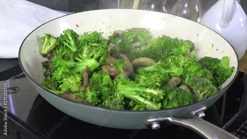 Broccoli and mushrooms simmering in a cast iron skillet