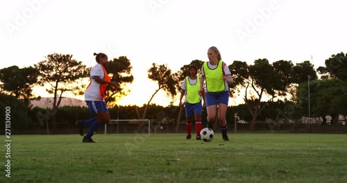 Female soccer player getting tackled down by competition.